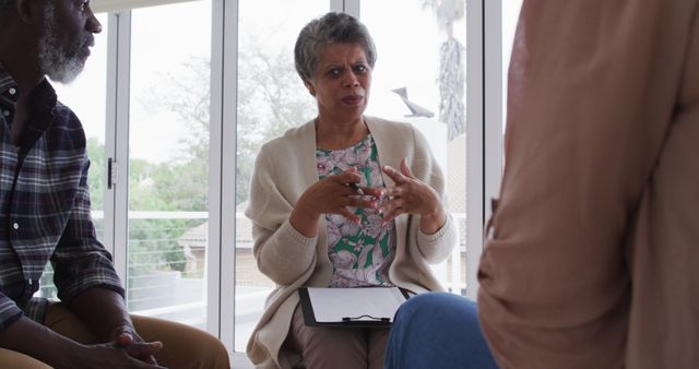 Older woman leading discussion in therapy session - Download Free Stock Images Pikwizard.com