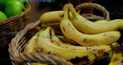Displaying ripe yellow bananas in woven basket with green apples and blue scanline overlay