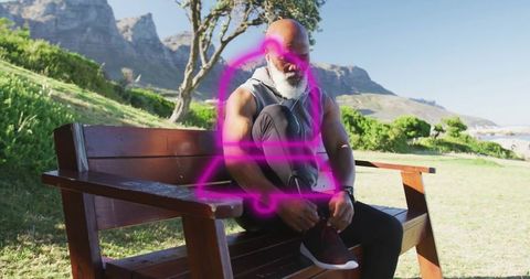 Elderly Man Tying Running Shoe Laces in Scenic Park