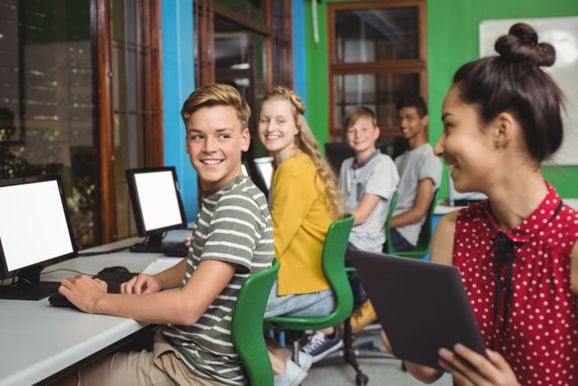 Students are using digital devices like tablets and computers in a modern classroom. They are smiling and appear engaged in their work, indicating a positive learning environment. This image is ideal for educational content, technology in education, school brochures, and articles about modern teaching methods.