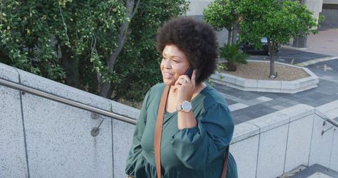 Confident plus size woman talking on smartphone outdoors