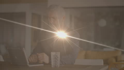 Man Using Laptop Surrounded by Digital Light Effects