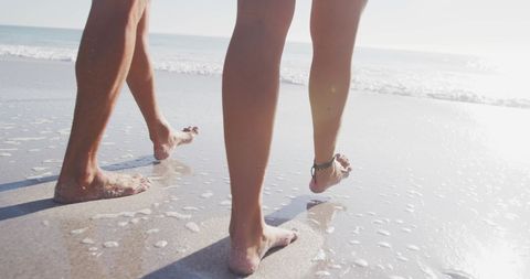 Couple Walking Along Sunny Beach Shoreline - Download Free Stock Images Pikwizard.com