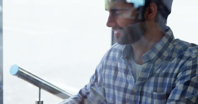 Smiling Bearded Man Working on Laptop Near Window - Download Free Stock Images Pikwizard.com