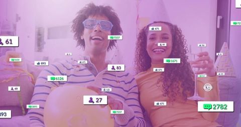 Couple celebrating live stream with social engagement overlays, balloons and champagne
