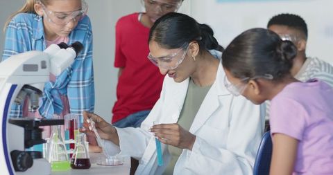 Diverse teacher and students conducting science experiment in laboratory