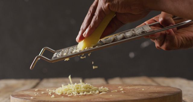 Close-Up of Hands Grating Cheese Over Wooden Cutting Board - Download Free Stock Images Pikwizard.com