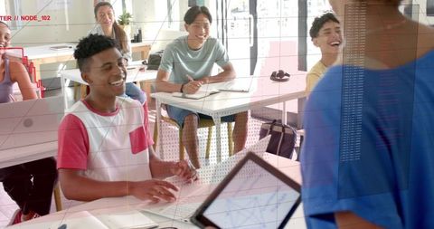 Students laughing and engaging with tablet-toting teacher in bright modern classroom