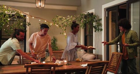 Friends Clearing Table After Dinner Enjoying Celebration