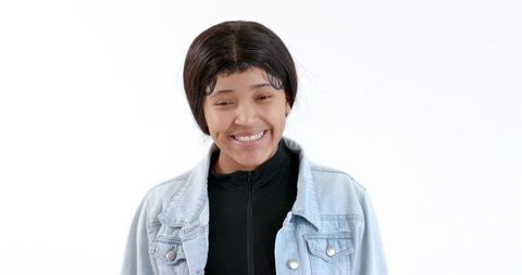 Young woman smiling in denim jacket reflecting confidence