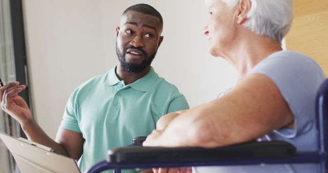 Healthcare worker having a meaningful conversation with an elderly patient at a residential facility. The healthcare worker is holding a clipboard, indicating assessment or consultation. Great for illustrating patient care, senior lifestyle, nursing homes, and healthcare professional interactions.