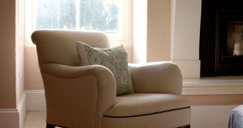 Cozy beige armchair by window in serene indoor setting
