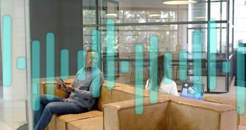 Coworking collaboration on tablet and laptop in modern lounge with teal data overlay