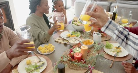 Happy Family Toasting at Thanksgiving Celebration Table