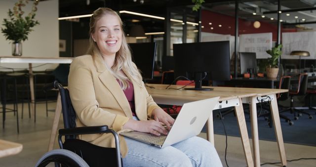 Smiling Woman in Wheelchair Working on Laptop in Modern Office - Download Free Stock Images Pikwizard.com