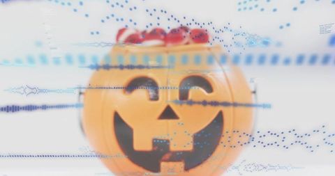 Glitch halloween jack-o'-lantern candy jar with blue data overlay, macro still life