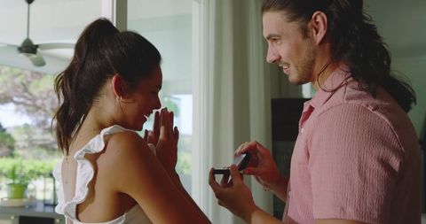 Joyful couple surprised with romantic gift exchange at home