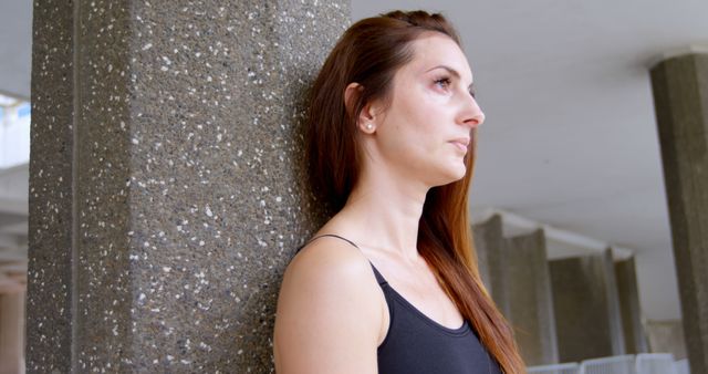 Thoughtful Young Woman Leaning on Concrete Column - Download Free Stock Images Pikwizard.com