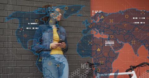 Woman leaning on brick wall holding smartphone by bike with world map hud overlay