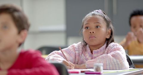 Attentive young student writing in classroom