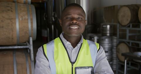 Confident man in microbrewery with barrels in background