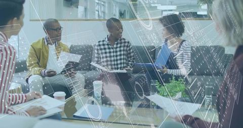 Team collaborating in modern office lounge with data visualization overlay and charts