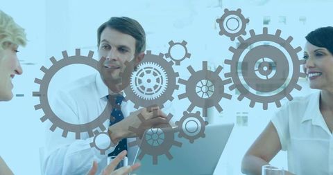 Business leaders collaborating with gear graphic overlay during modern office meeting