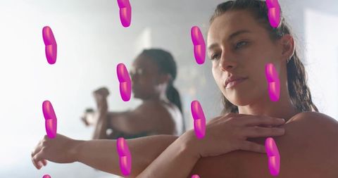 Midadult woman stretching arm across chest at dance studio with magenta overlays