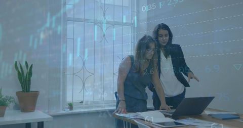 Businesswomen analyzing data in modern office