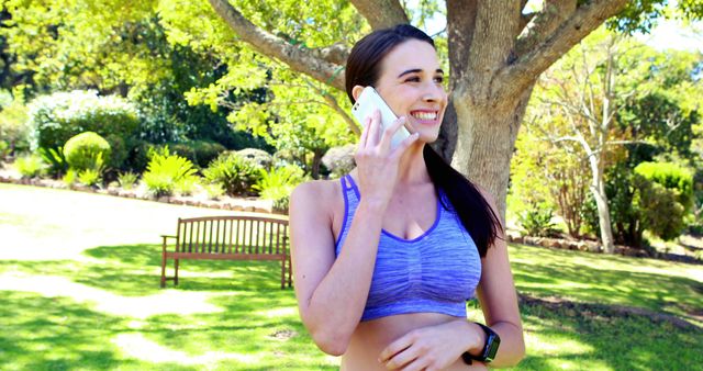 Smiling Woman in Sports Bra Talking on Phone Outdoors - Download Free Stock Images Pikwizard.com