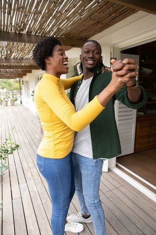 Romantic African American Couple Dancing Outdoors on Sunlit Deck