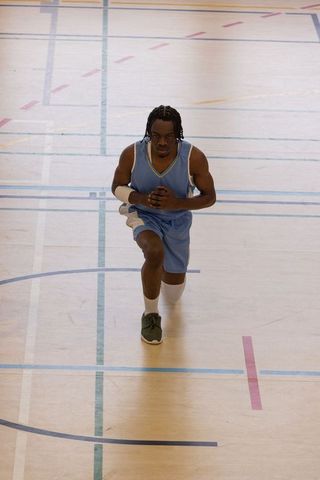 Male Athlete Performing Lunge Exercise on Basketball Court