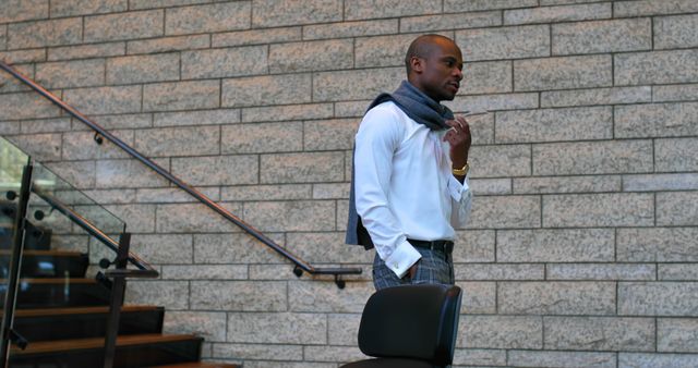 Stylish Man in Winter Attire Standing Near Modern Staircase - Download Free Stock Images Pikwizard.com