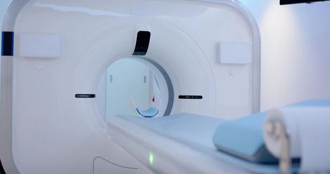 Modern mri/ct scanner gantry featuring sliding patient table and pale blue headrest