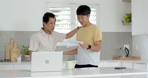 Father and Son Celebrating Success in Modern Kitchen