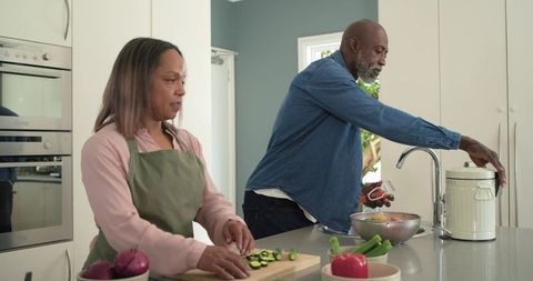 Mature couple preparing healthy meal together in bright modern kitchen