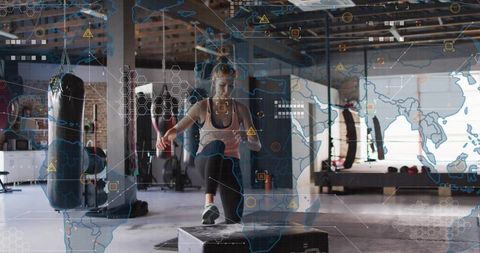 Woman performing plyometric box jump in industrial gym with digital hud overlay
