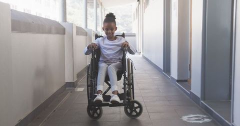 Young African American Girl in Wheelchair Moving Through School Corridor Embracing Education - Download Free Stock Images Pikwizard.com