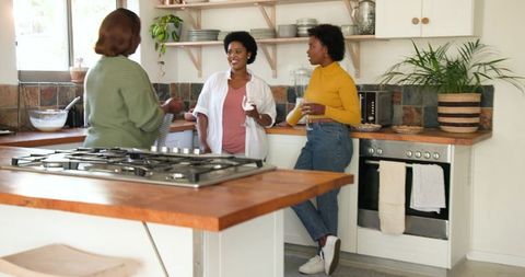 Joyful Friends Conversing in Bright Kitchen Environment