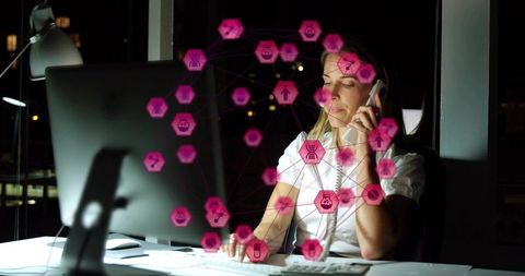 Nighttime office worker calling and typing with neon magenta data network hexagon icons