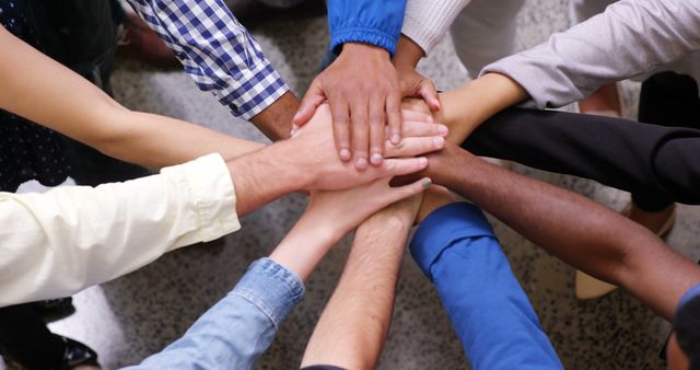 Hands of business team stacking their hands together in office