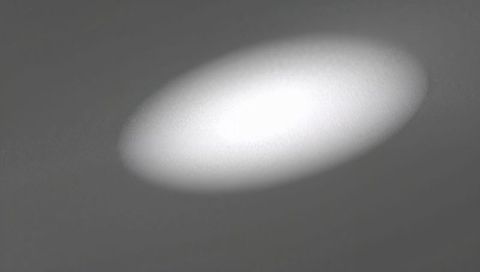 Oval spotlight casting soft halo glow on smooth textured wall minimal abstract interior