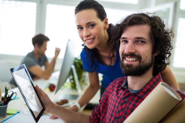 Male and female graphic designers using digital tablet in office