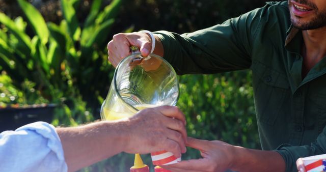 Friends Pouring Lemonade Outdoors on Sunny Day - Download Free Stock Images Pikwizard.com