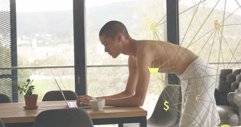Man Wrapped in Towel Typing on Laptop in Modern Living Space