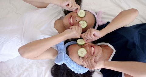 Teen friends enjoying fun spa day with cucumber slices