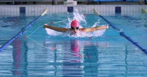 Female Swimmer Performing Butterfly Stroke, Powerful Breathing with Pink Cap and Goggles