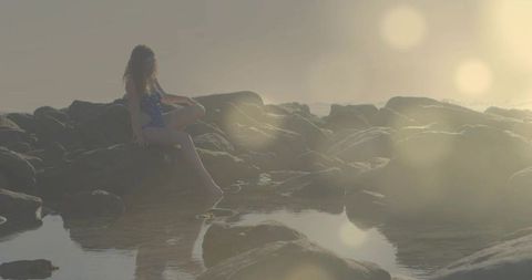Woman relaxes by tide pool in serene coastal ambience