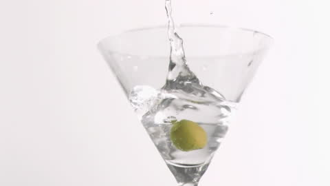 Olive Splashing Into Martini Glass for Refreshing Twist