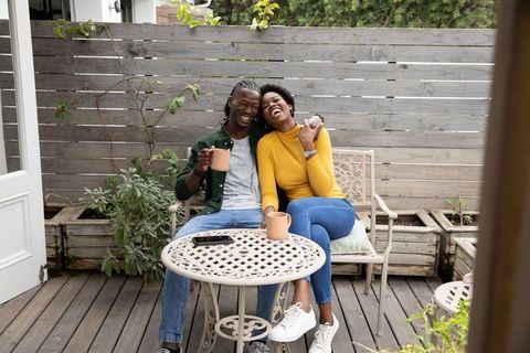 Happy Couple Enjoying Coffee on Wooden Deck in Outdoor Setting